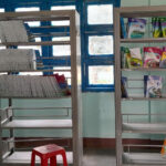 Empty bookshelves in a rural school library in Vietnam, showing severe shortage of age-appropriate reading materials